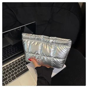 Détail d'une pochette matelassée argentée métallisée avec motif quadrillé et fini brillant