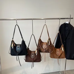 Grands sacs cabas minimalistes unis et à motif léopard suspendus sur un portant