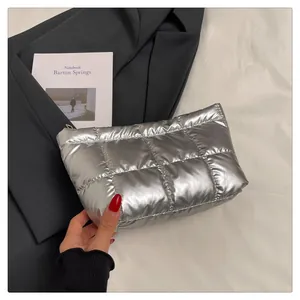 Gros plan d'une pochette matelassée argentée au design bouffant et zippé élégant