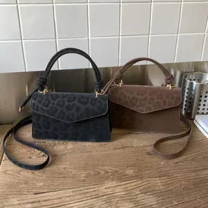 Top view of leopard print crossbody bags in black and coffee with knotted top handles