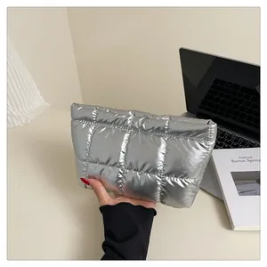 Gros plan d'une pochette matelassée argentée au fini métallique dans un cadre de bureau