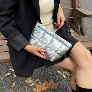 Pochette argentée matelassée pour femme, style puffer chic, dans un décor d'automne