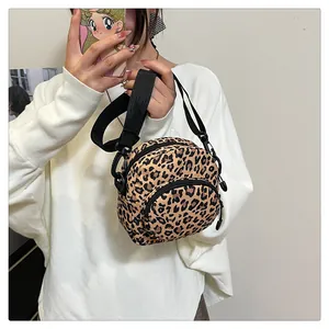 Detail view of the leopard print crossbody bag with fabric texture and dual zipper pockets
