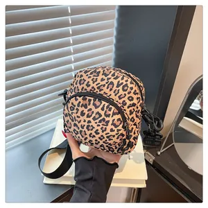Detail of trendy leopard print crossbody bag with front zipper and adjustable wide strap