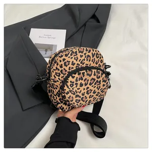 Detail of trendy leopard print mini crossbody bag with double zippers and black strap
