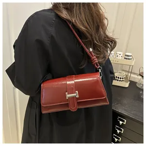 Close-up of a burgundy vintage leather underarm bag with silver buckle and knot strap detail