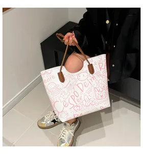 Dettaglio della grande borsa tote bianca con motivi graffiti rosa e manici marroni fini