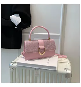 Detailed view of pink crossbody bag with glitter finish and golden horseshoe clasp