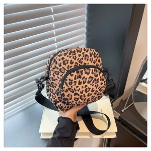 Detail of leopard print crossbody bag featuring a front round pocket and wide strap