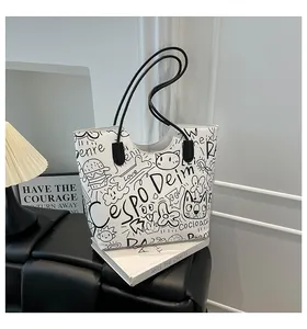 Dettaglio della borsa shopper bianca con motivi graffiti neri e manici in pelle