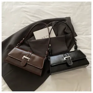 Detail showing glossy oil wax leather bags with metal T-buckle and knotted strap