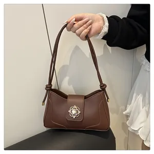 Detail of vintage dark brown faux leather bag featuring a gold floral cutout metal buckle