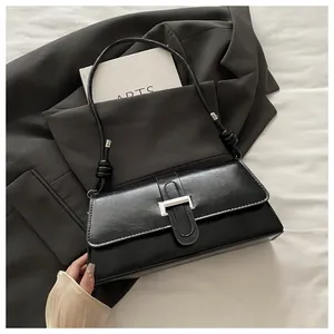 Detail of minimalist black PU leather bag with silver metal buckle and rope knot strap