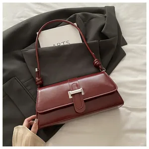 Detail of burgundy leather handbag with silver clasp and knotted shoulder strap detail