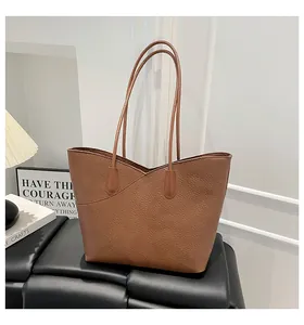 Detail of premium brown pebble leather tote bag with unique V-cut opening and long straps