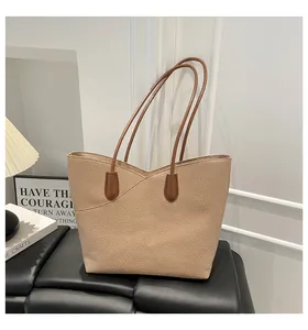 Detail view of beige lychee pattern tote bag with brown straps and V-shaped design