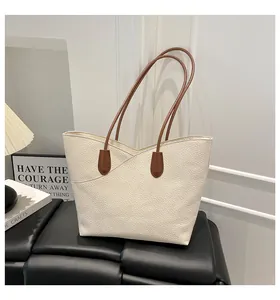 Detail of white lychee grain leather tote bag with brown straps for commuting