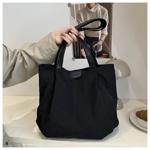 Détail du sac cabas en nylon plissé noir avec étiquette en cuir et doubles anses
