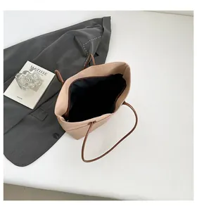 Detail view of large apricot tote bag showing interior black lining and pebble leather texture