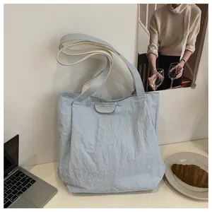 Vue détaillée du sac cabas bleu clair texturé avec écusson FASHION en décor de bureau