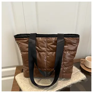 Detail of coffee brown quilted puffer tote bag with glossy water-resistant nylon texture