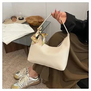 Detail of hobo bag in cream pebbled leather with a decorative floral silk scarf