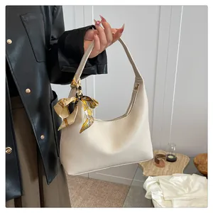 Detail of cream lychee texture hobo bag with a decorative geometric print silk scarf
