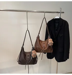 Detail view of leather shoulder bags with tassel drawstrings and floral metal clasps