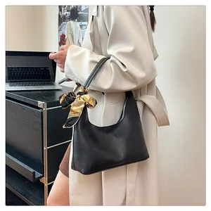 Detail of black crescent hobo bag in lychee leather featuring a decorative silk scarf