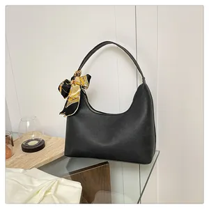 Detail of black pebbled leather hobo bag with vintage silk scarf on gold zipper