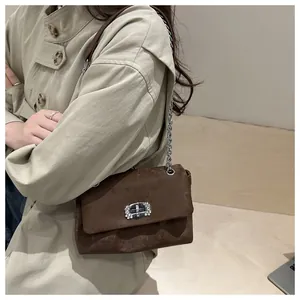 Détail du sac à bandoulière en daim marron avec boucle en argent sertie de cristaux brillants