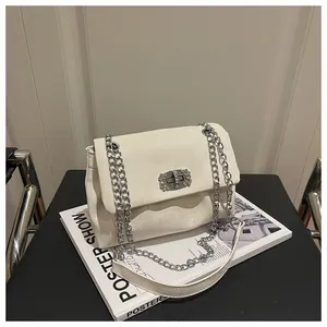 Détail du sac à bandoulière blanc en similicuir texturé avec boucle en diamant argenté