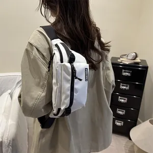 Sac de poitrine minimaliste en nylon blanc avec sangle noire réglable et poche avant zippée