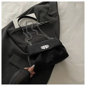 Détail d'un sac à main en velours noir avec boucle en strass argentés et bandoulière