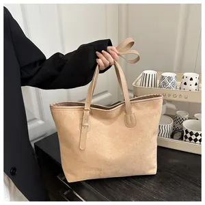 Macro detail of beige suede tote bag showing soft leather texture and metal buckle