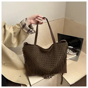 Close-up of brown woven tote bag with V-shaped patterns and long hanging tassels detail