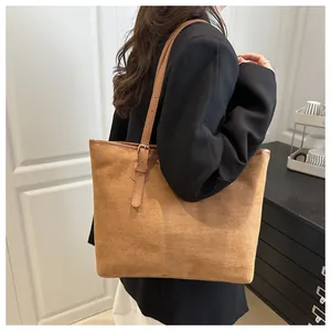 Close-up of suede texture and adjustable metal buckle on brown large tote bag