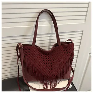 Detailed close-up of dark red tote bag with bohemian fringe texture and tassels