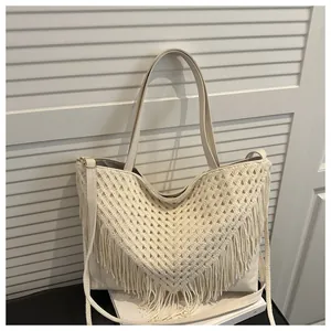 Detail view of cream crochet tote bag featuring intricate hollow patterns and long tassels