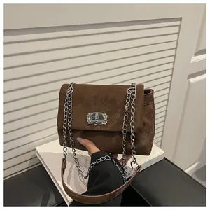 Détail du sac bandoulière en suédine avec boucle en strass argentés et chaîne en métal