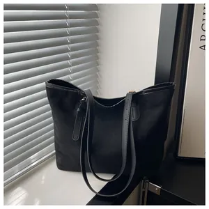 Close-up of black suede tote bag with leather straps and natural light shadow texture