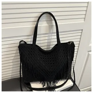 Detail of black tassel tote bag with dark leopard print and woven fringe accents
