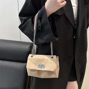 Sac bandoulière beige avec chaîne et boucle en diamant porté avec un blazer noir chic