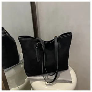 Macro view of matte black tote bag showing soft texture and premium faux leather straps