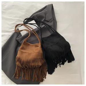 Vue détaillée des sacs seaux bohèmes avec de longues franges en daim marron et noir
