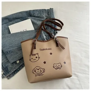 Detailed view of beige tote bag featuring cute cat prints and adjustable strap in cozy setting