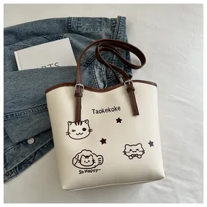 Detailed view of cream PU bucket bag featuring a minimalist cat print and brown strap