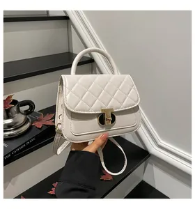 Detail van de beige gewatteerde handtas met metalen draaisluiting en rond handvat