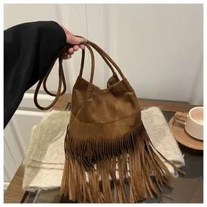 Vue détaillée du sac seau en daim marron foncé avec de longues franges décoratives