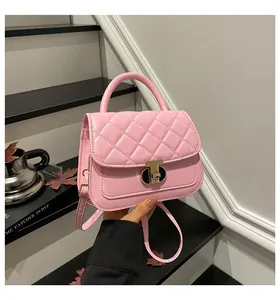 Detailopname van roze gewatteerde crossbodytas met gouden sluiting en handvat